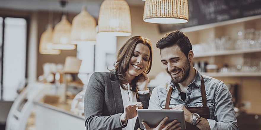 Mulher e homem a consultarem um tablet num comércio de retalho