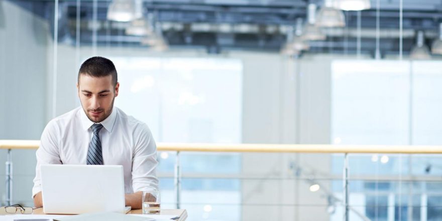 Jovem empresário homem de gravata a consultar o decreto lei 28 2019 no computador portátil