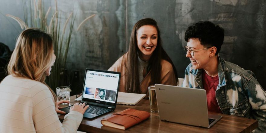 Três mulheres a trabalhar com os seus computadores portáteis laptops e a gerir pessoas